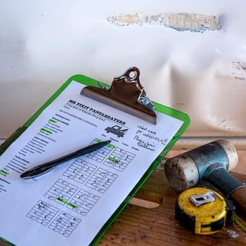 Insurance paperwork sits next to a wall with water damage caused by a leaking roof.