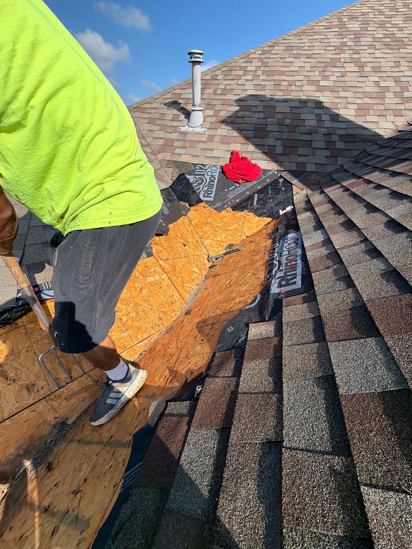 Divided Sky crew member carefully repairing individual roof shingles