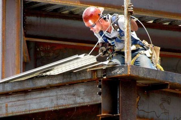 Professional roofer installing a TPO roofing system on a commercial building