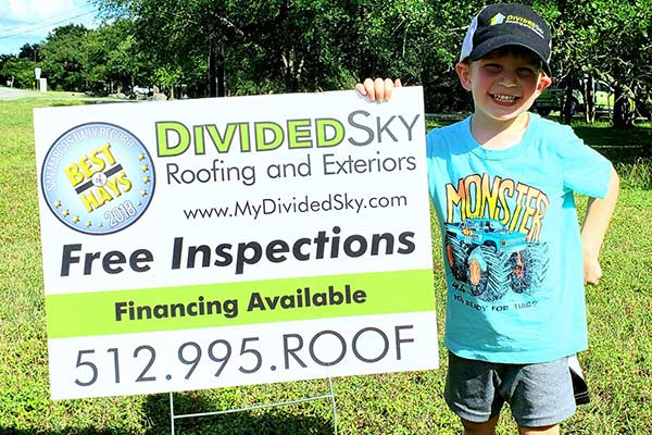 Divided Sky owner John Hardy's son Tucker stands beside a sign advertising the company.