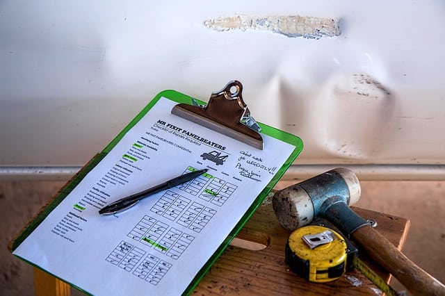 Insurance paperwork sits next to a wall with water damage caused by a leaking roof.