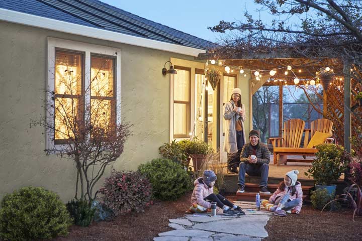 Family outside a solar roofing home