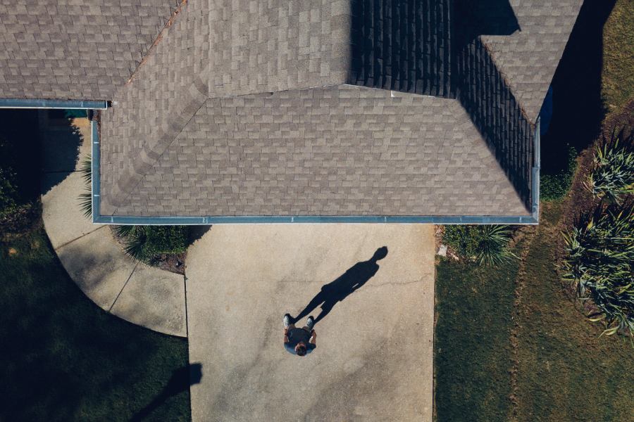 Man looking at his house and thinking about what kind of shingles will be best for it