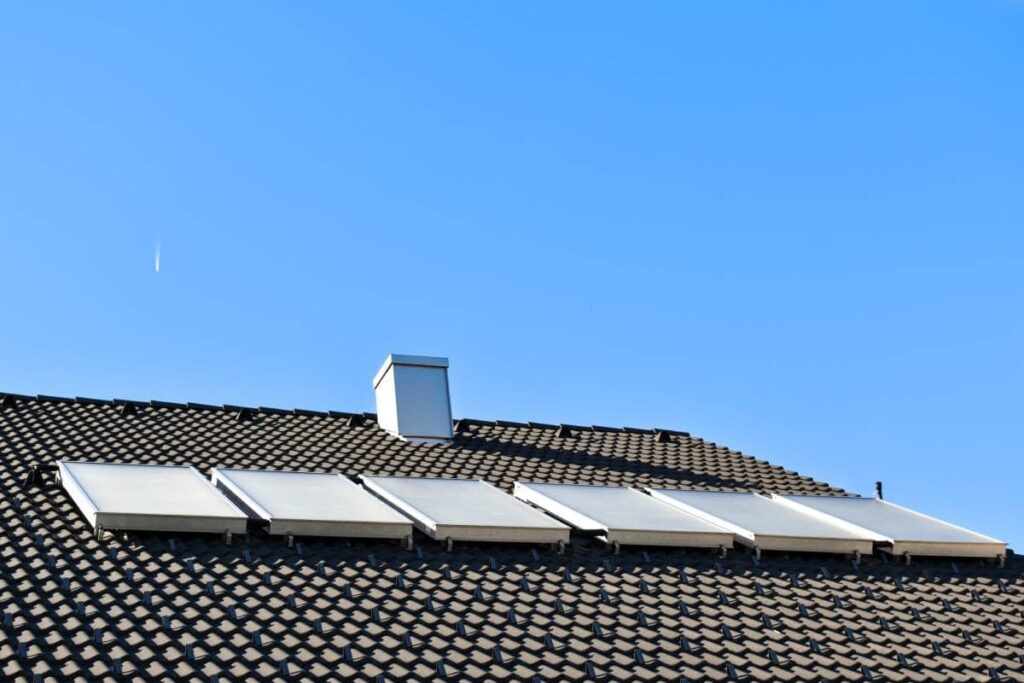 A house with Round Rock roofing and solar under a clear blue sky.
