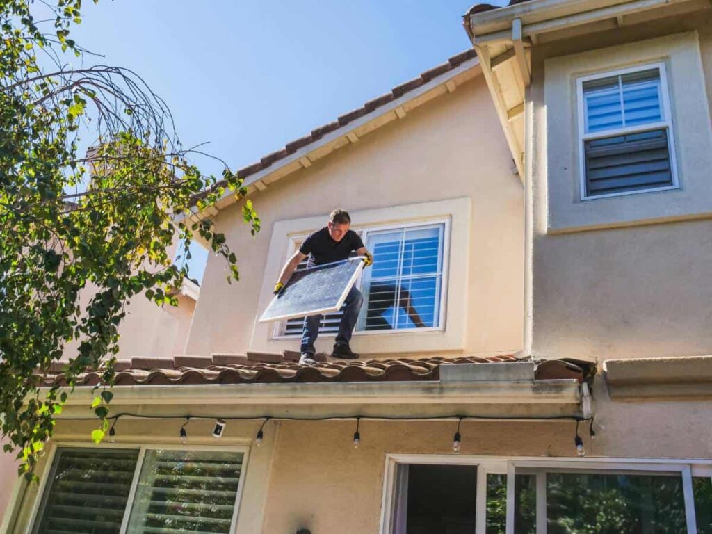 Man Doing Roof Repair and Upgrading to Solar Panel Roof