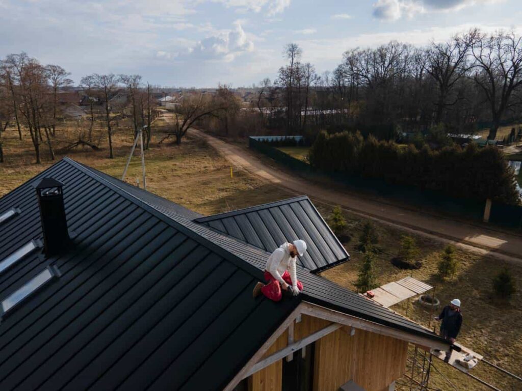 San Marcos roofers working on a new black metal roof installation.