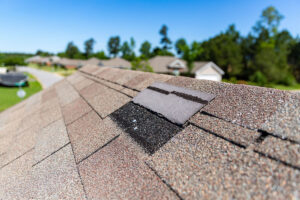 A roof is missing shingles due to storm damage.